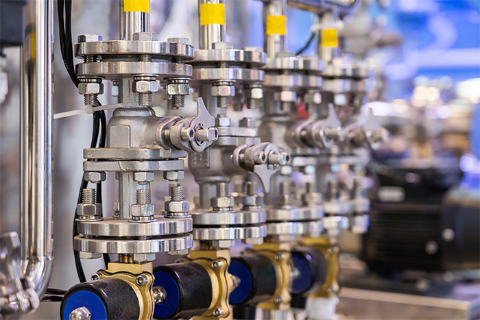 Stainless steel industrial pump system with multiple valves, piping and actuators in a process industry application, highlighting automated fluid control and precision engineering components.